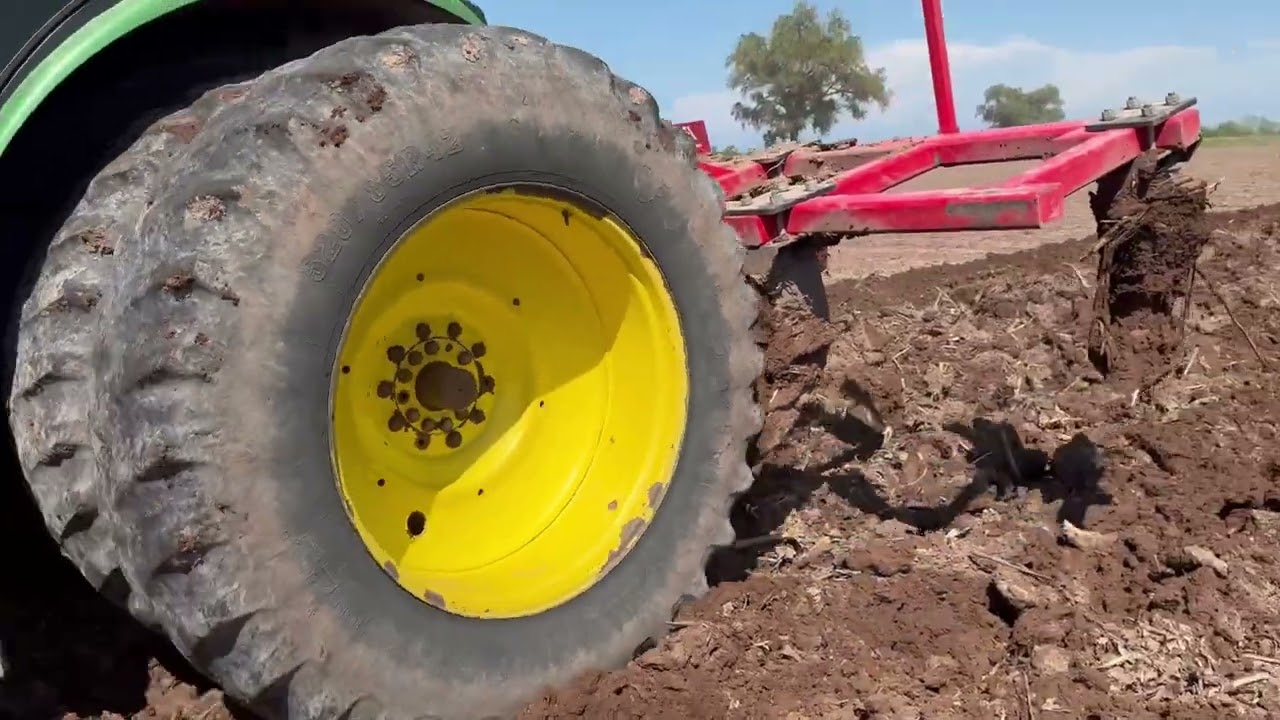 Trabajando la tierra con un Jhon Deere 8R con equipo pesado en barrial