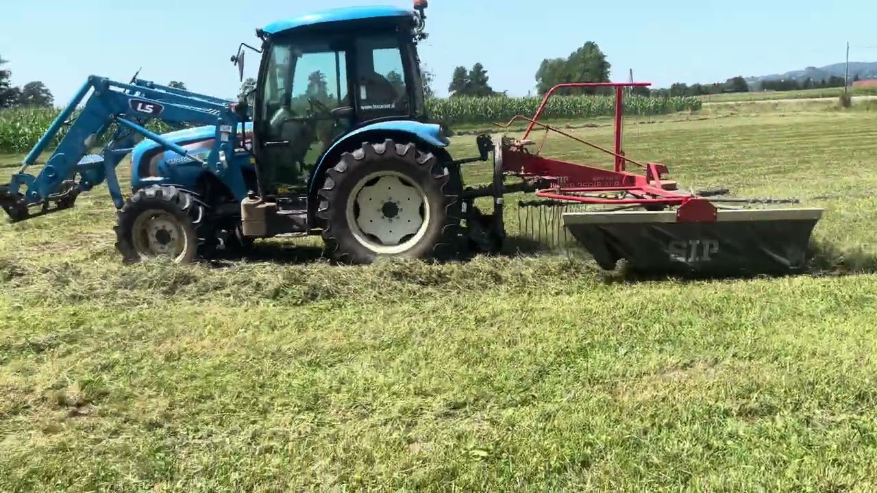 raking hay with tractor LS XU6168 and rake SIP star 350/8 LSP