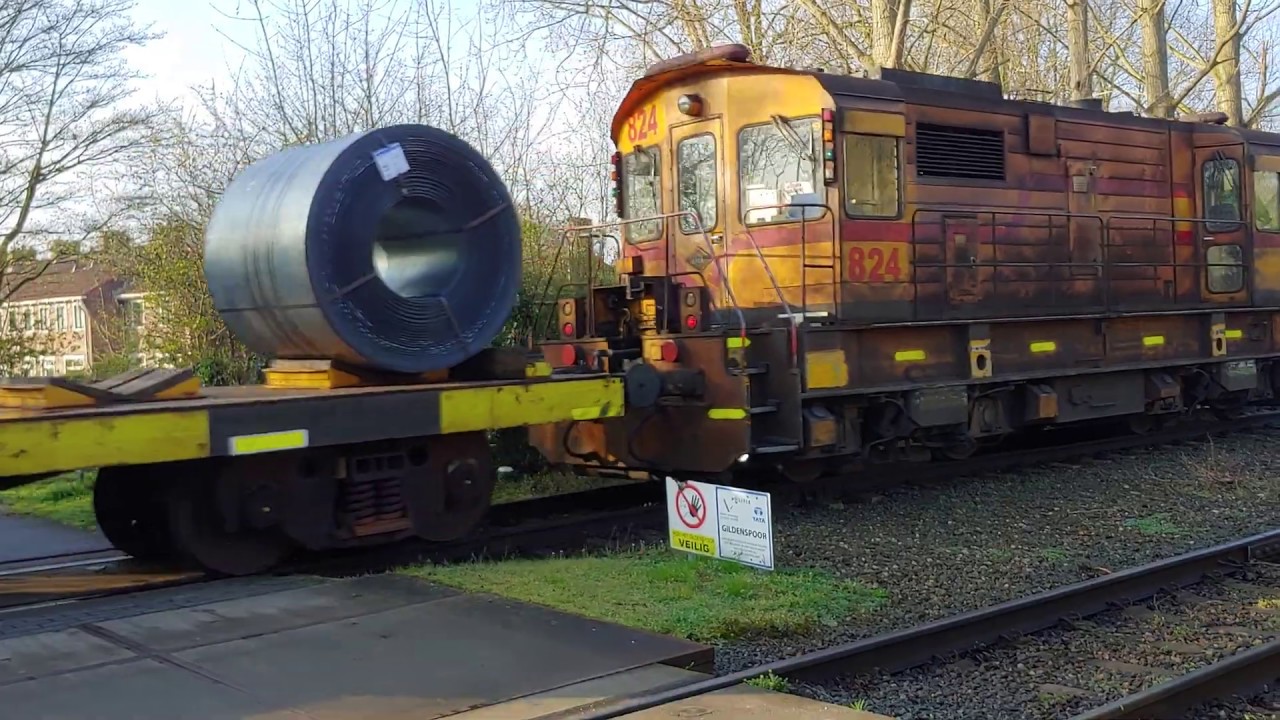 Tata Steel loc 824 + staalrollentrein passeert de overgang bij het Gildespoor in Velsen Noord