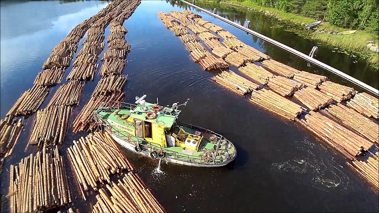 Tug Heinävesi preparing floating log bundles for towing in Oravikoski