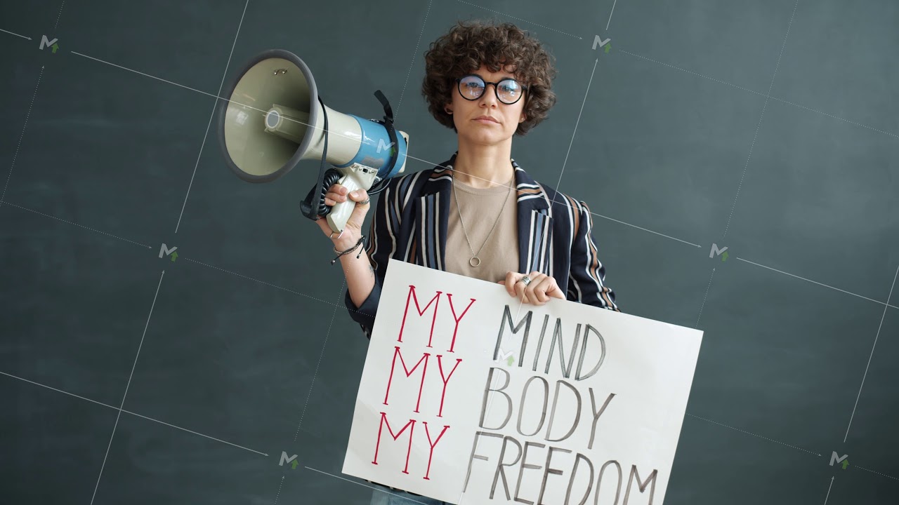 Portrait of strong woman holding my freedom banner and megaphone standing on black background