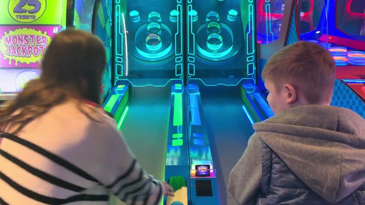 Zach has fun at Skeeball and scores!!