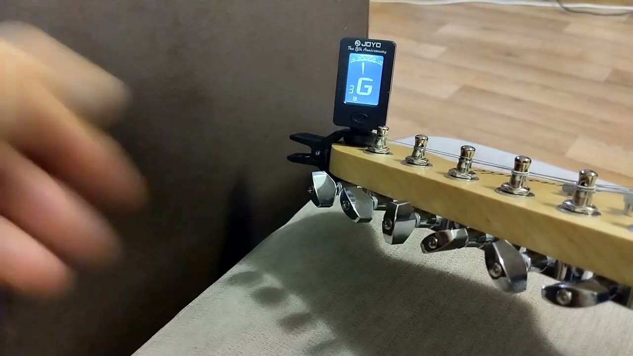 Tuning the strings of an electric guitar using a  tuner. My firs performance of the melody