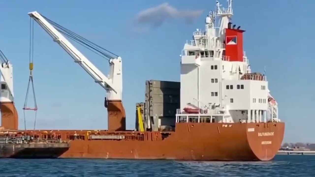 Transshipment of cargo on the high seas. A barge with cargo. Floating crane. Cargo ship.