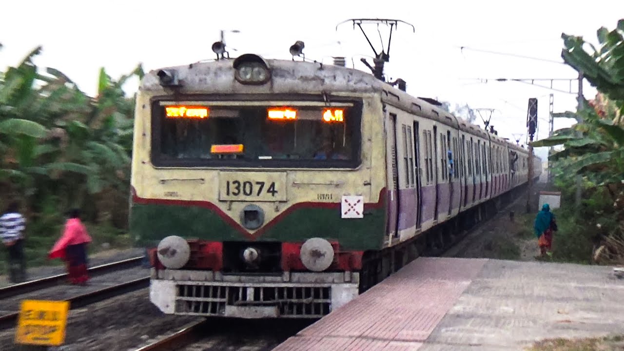 Green and Yellow Electric Multiple Unit local train made back to back crossing at dusky environment