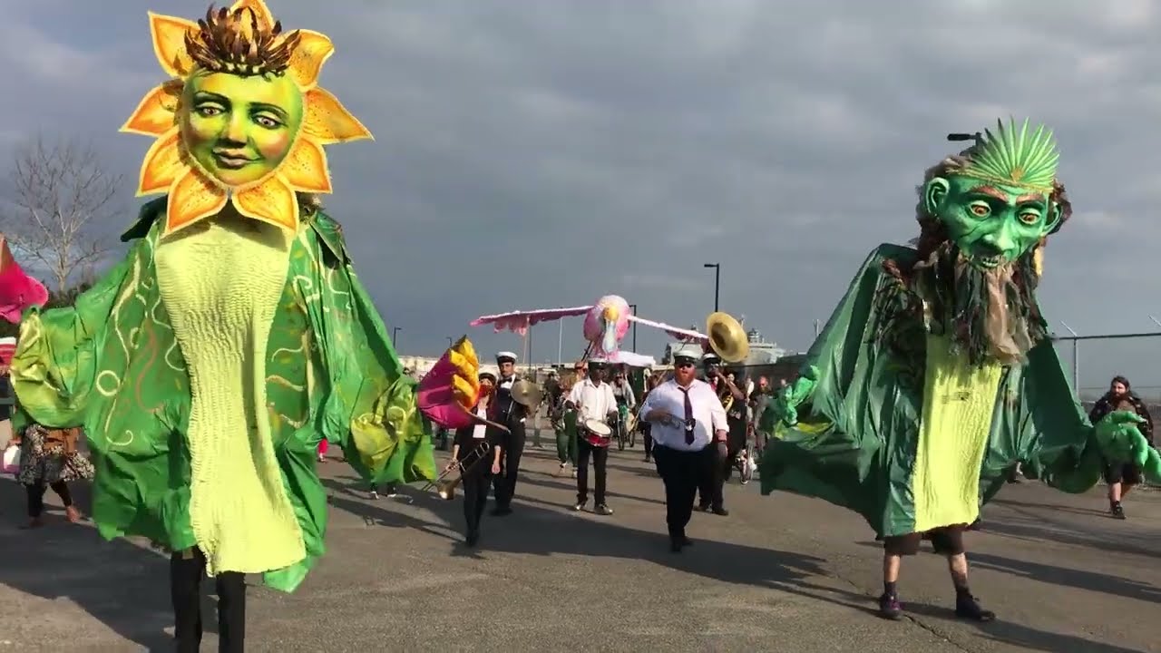 The giant puppet parade dances along the Mississippi River