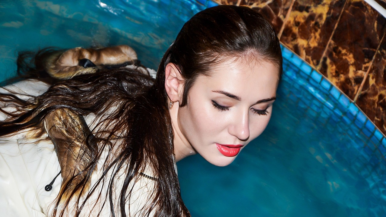 COOL WETLOOK! A CUTE GIRL IN A WARM JACKET GETTING WET IN THE POOL AND POSSING BRIGHTLY FOR YOU!