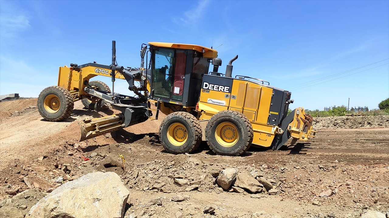 Motor Grader John Deere 670G pushing material working on the Vía Central project, a train for UPM
