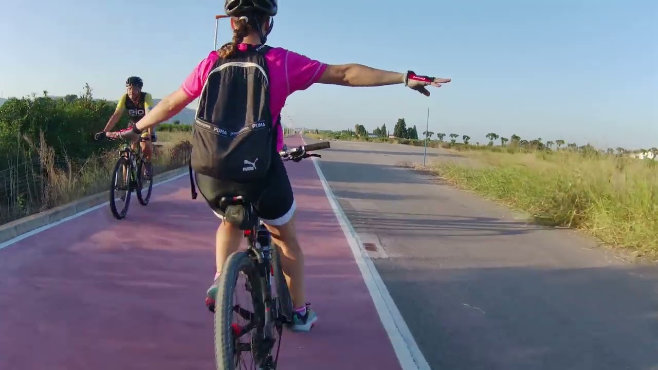 Recorriendo en bicicleta la Vía Xurra, una Vía Verde entre naranjos en las afueras de Valencia.
