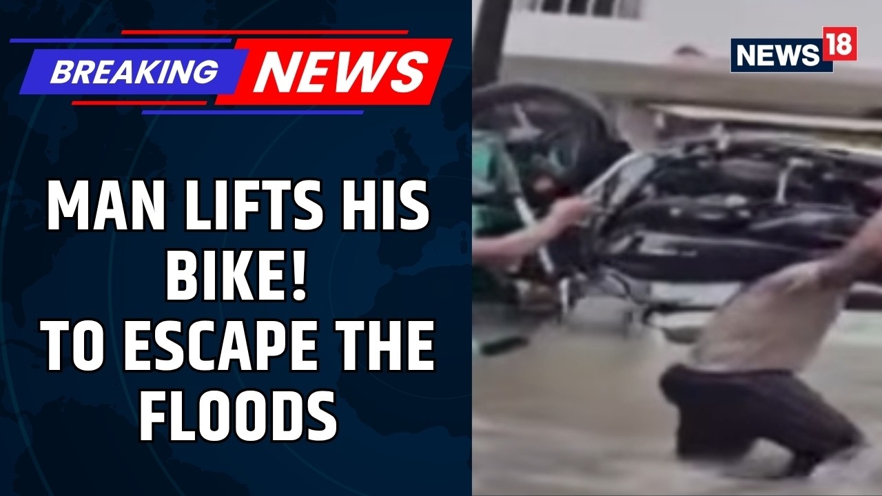 Navsari Man Carries Motorcycle on Shoulders Through Flooded Streets Amid Heavy Rain | News18