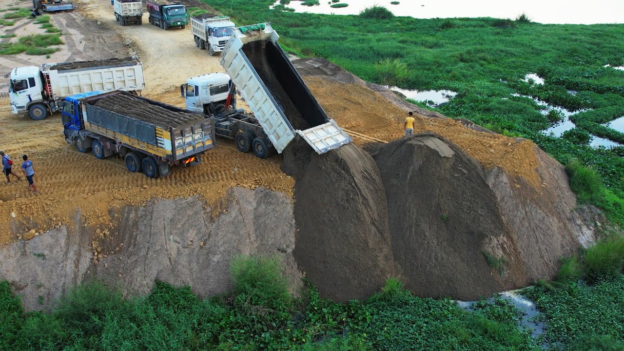 Dump Truck Unloading Sand And Gravel - Bulldozer Spreading Gravel Back Fill View ( Drone No Sound )