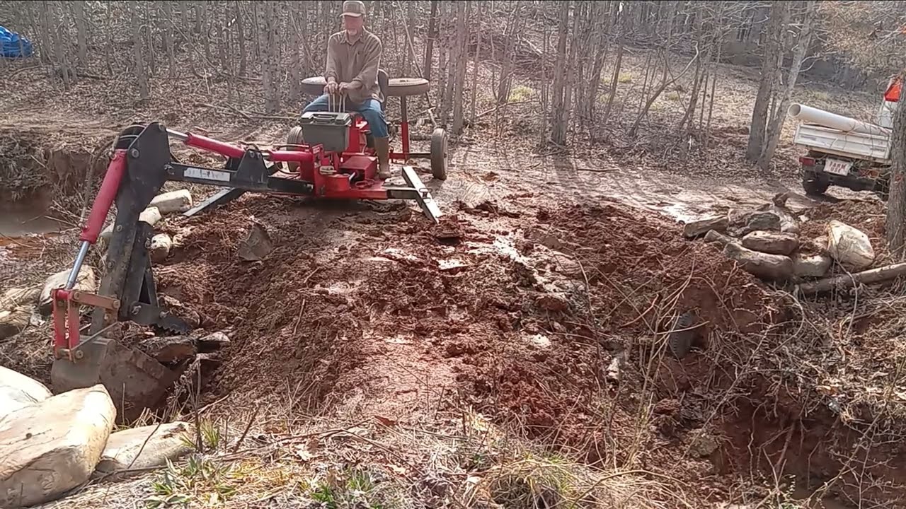 Harbor Freight trencher removing the old spillway.