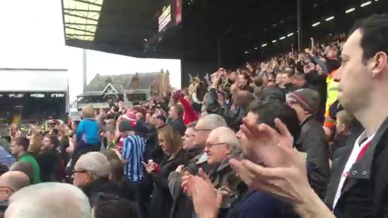 Brentford supporters celebrate their team's first goal against Fulham at Craven Cottage.