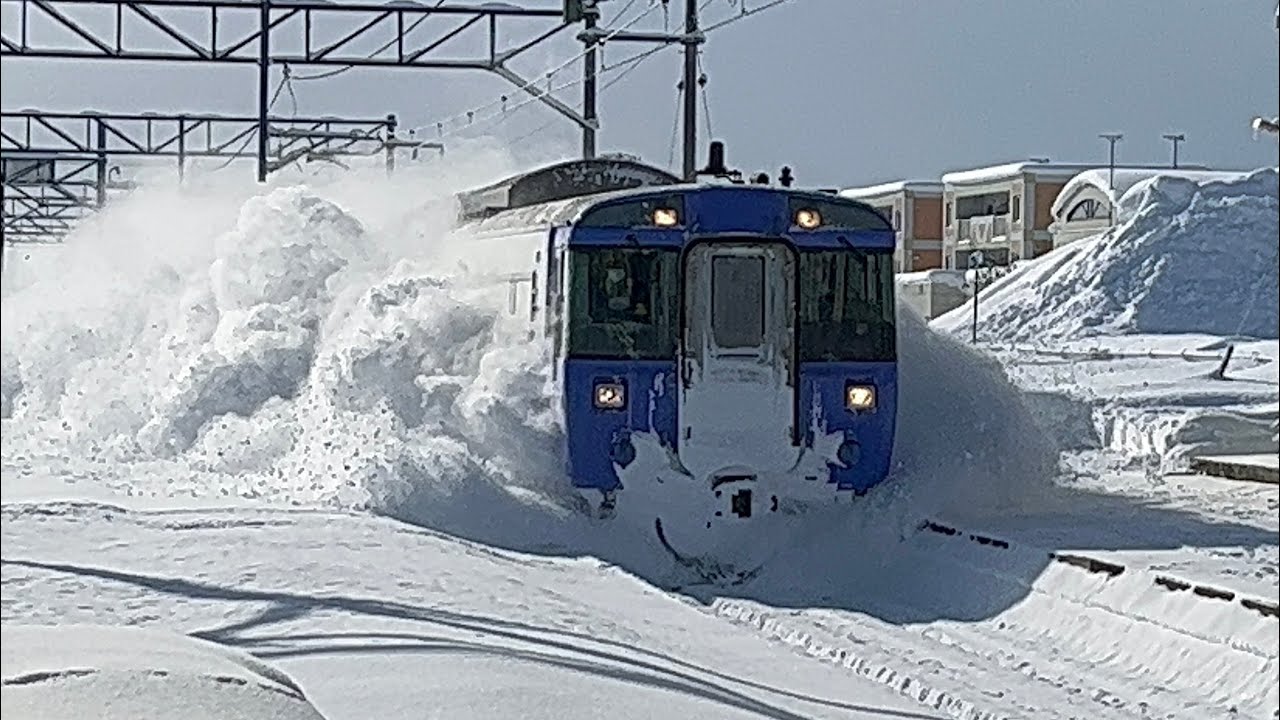 Limited express trains passing through JR Hokkaido Moseushi Station with snow and smoke