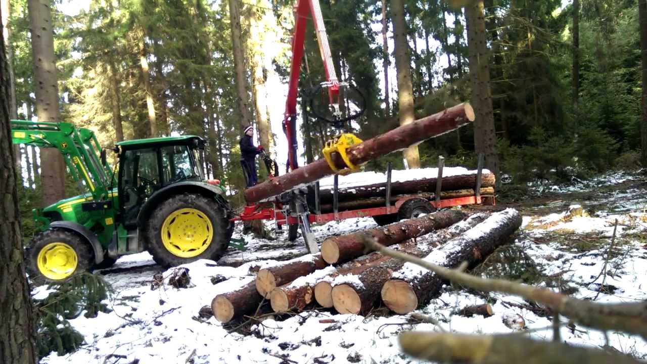 John Deere 5070M mit Perzl PRW 6 Brennholzwagen beim laden.