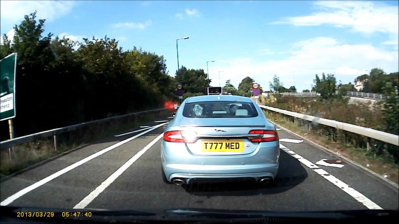 Impatient car driver slowly sneaks past queue of traffic