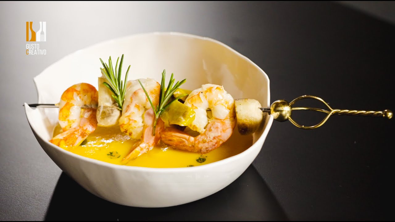 LA CREMA DI CAROTE CON ZENZERO E ROSMARINO, SERVITA CON SPIEDINO DI GAMBERI E FUNGHI CHAMPIGNON