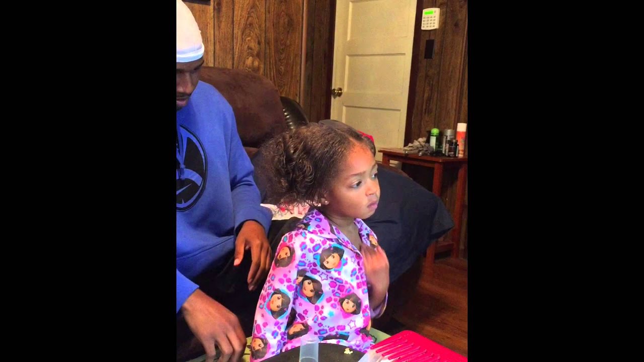 Father doing daughters hair.