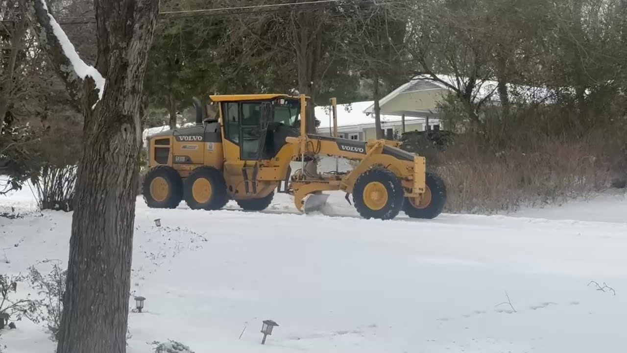 A snow plow scrapes a street in the Town and Country neighborhood in Winston-Salem