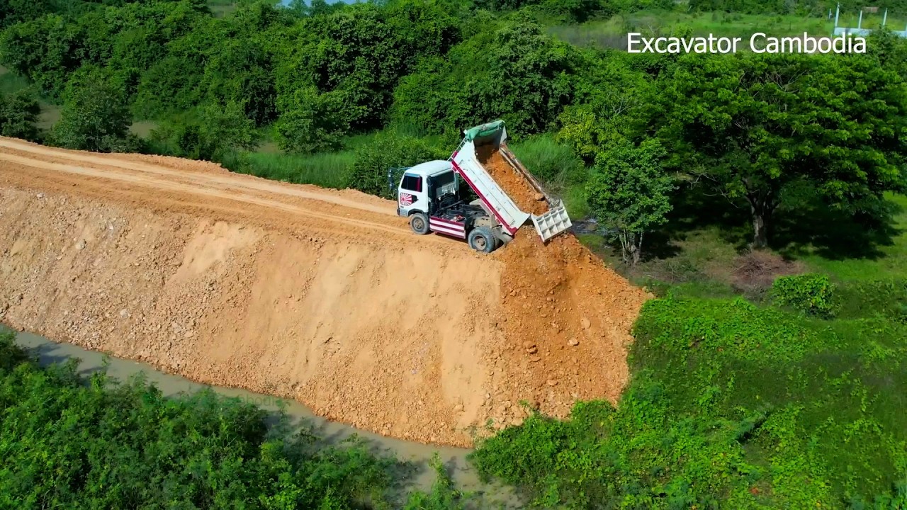 So Beautiful Mini Dump Truck Unloading Dirt Into Slope And Small Bulldozer Pushing Building New Dam.