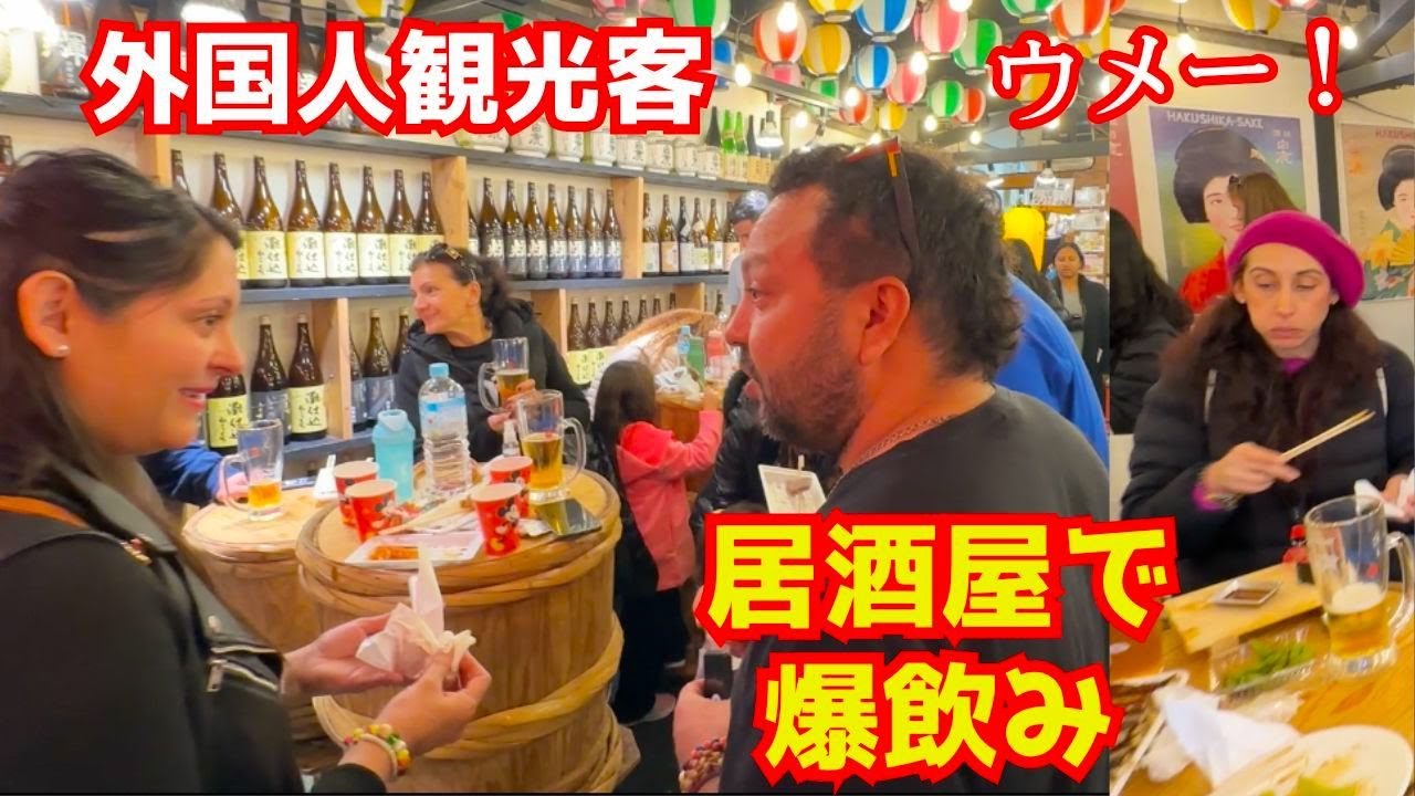 外国人観光客が日本の居酒屋でアサヒの生ビールと辛口の日本酒を爆飲みする