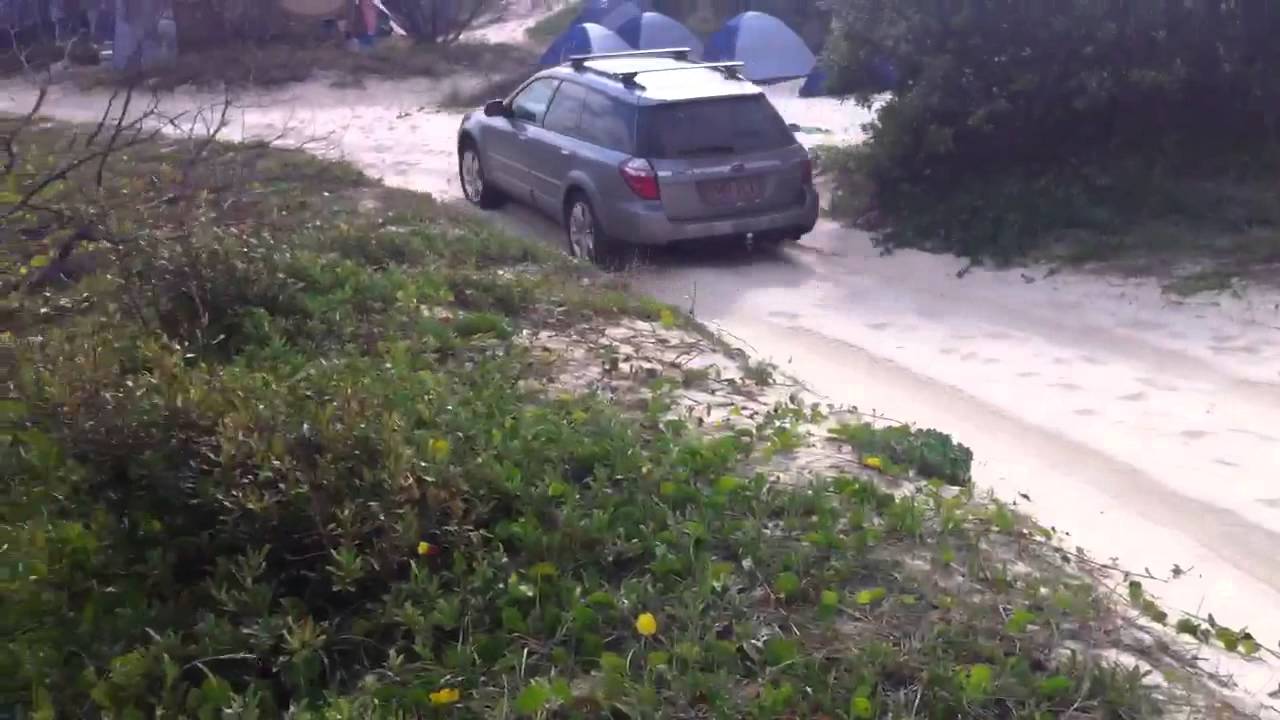 Subaru Outback going through soft sand on the beach at Fraser Island