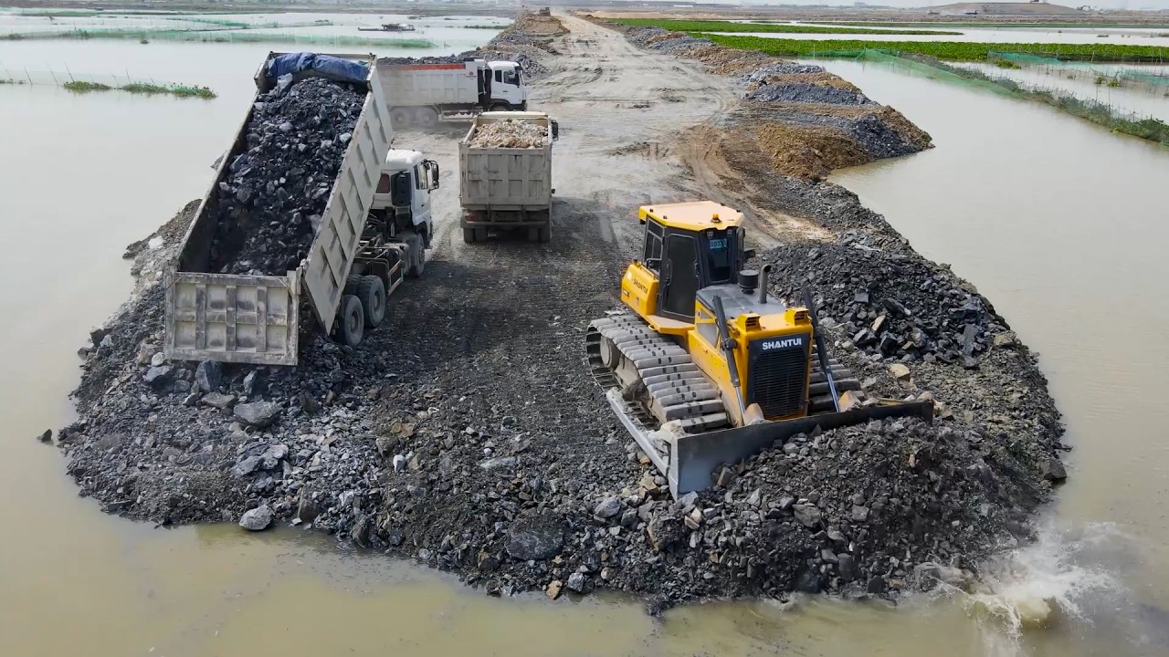 Nice Extreme Dump Truck Transport Stone into Lake and Bulldozer Push Stone Build Road On Huge Lake