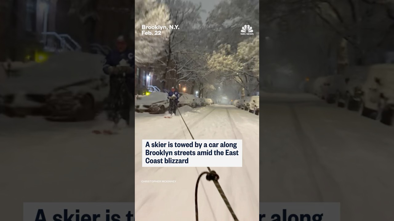 Skier towed by car on snow-covered Brooklyn streets