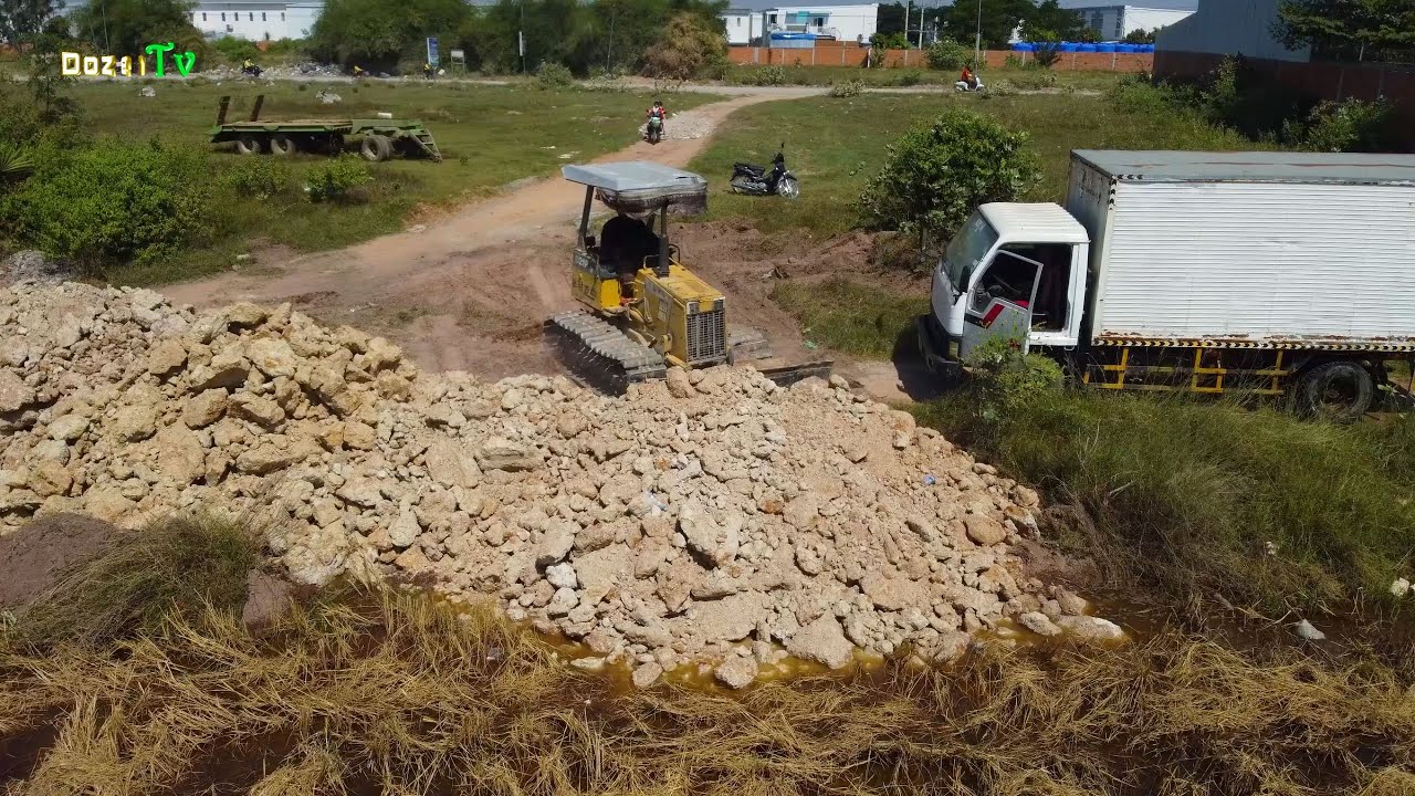 Best Land Filling Operation by Skilled Dozer & Dump Trucks Drivers Handling Stone and Soil Smoothly.