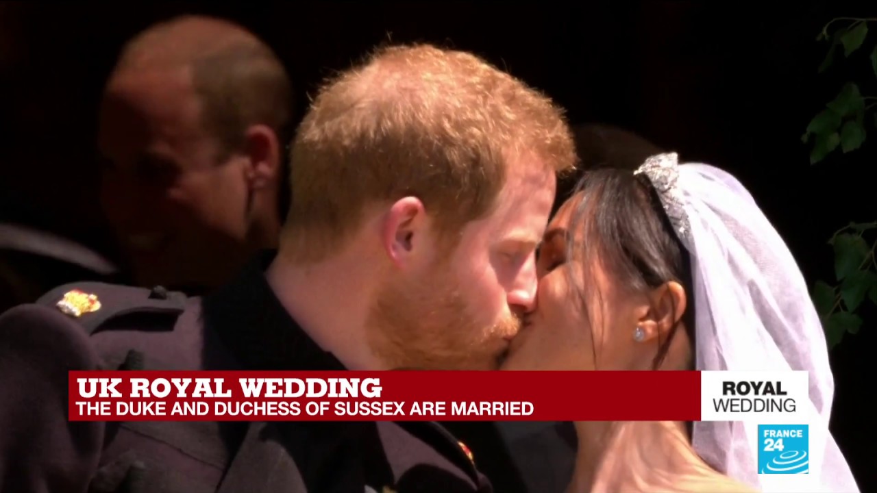The Duke and Duchess of Sussex kiss in front of St George's Chapel as they exit