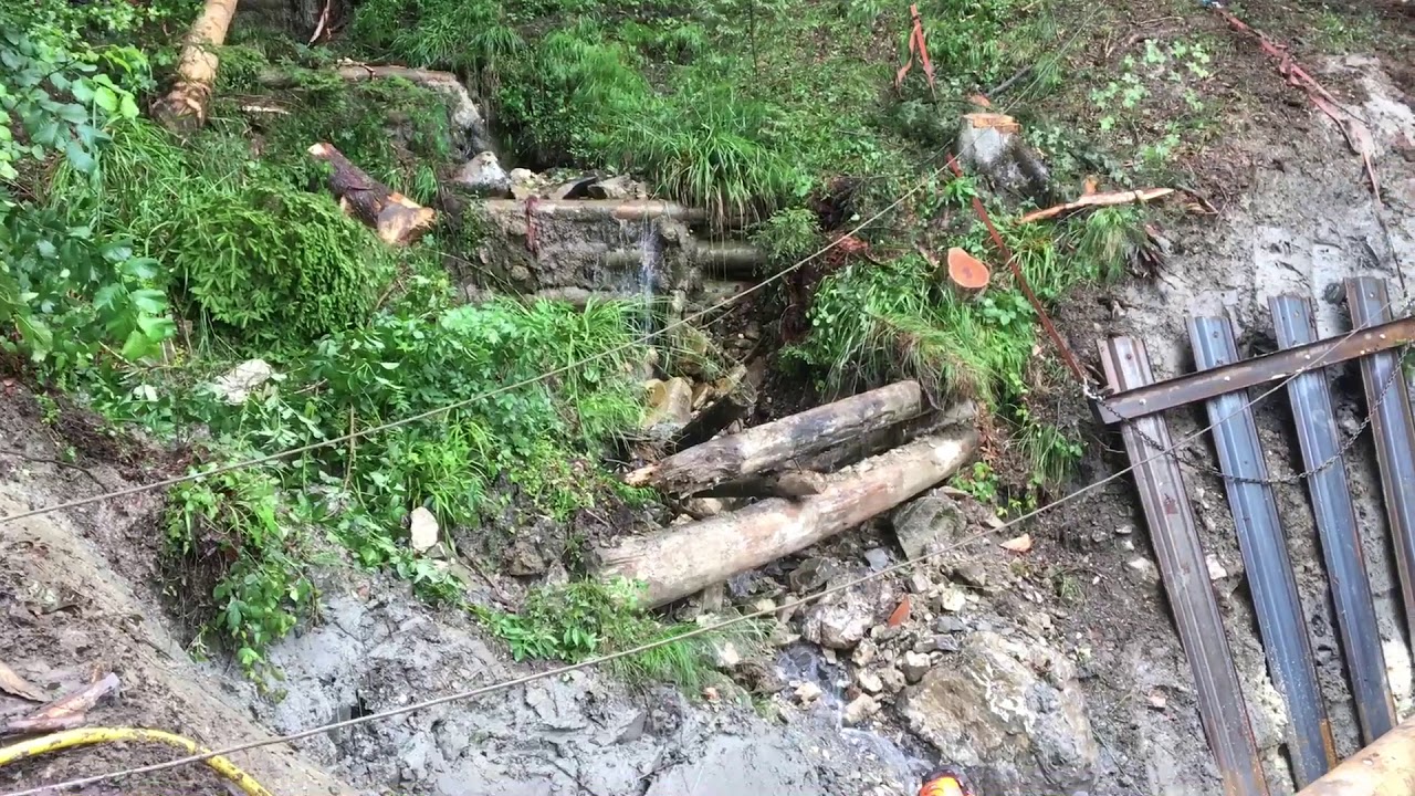 St.Galler Forstwart-Lernende errichten in Gams im steilen Wald eine Bachsperre aus Holz.