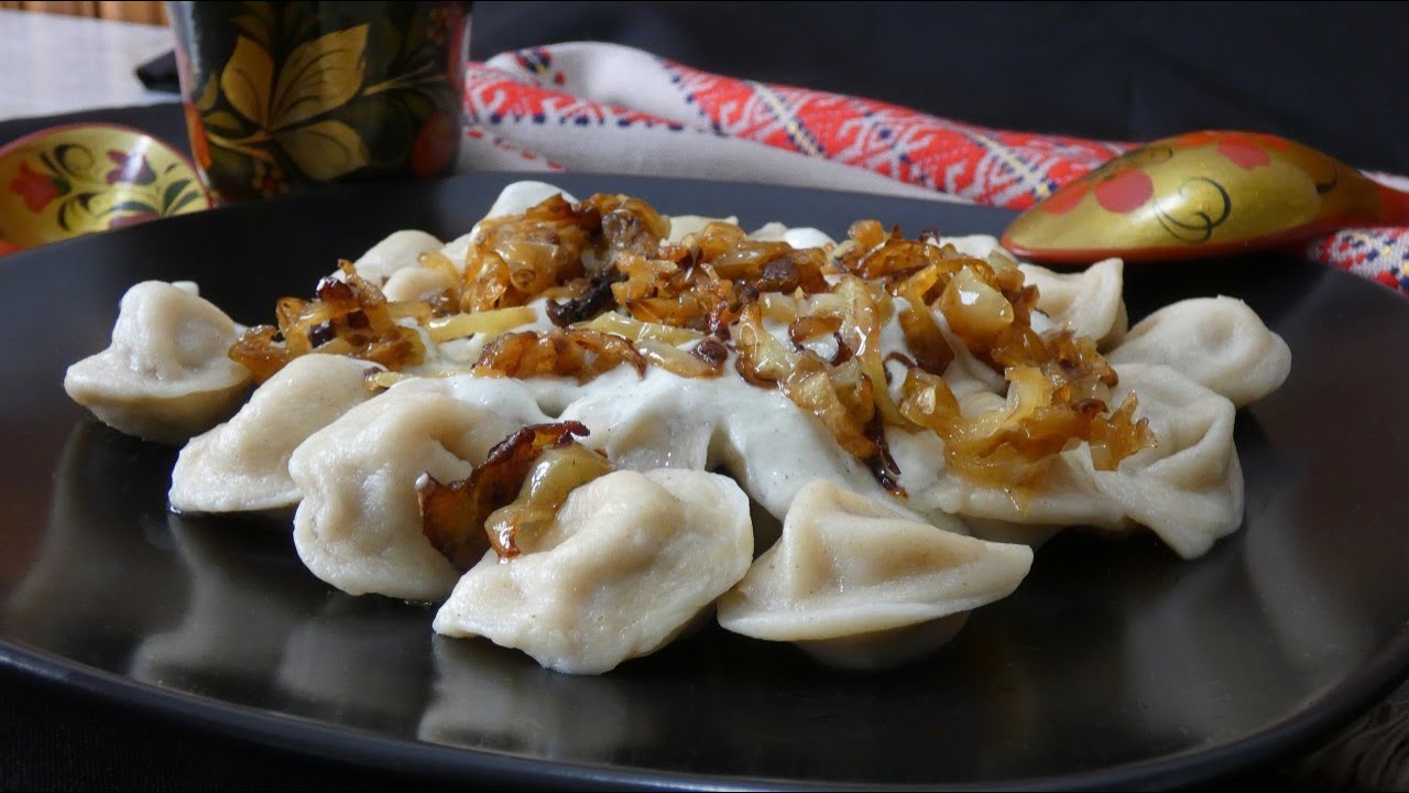 Pelmeni - meat filled dumplings with sauce and topping