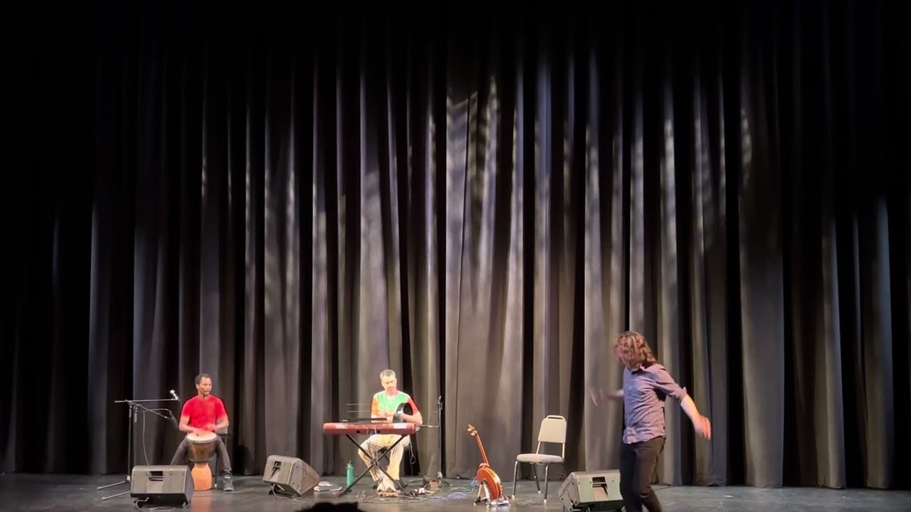 Dylan James dancing with Amos Gabia and Colin Harte on percussion