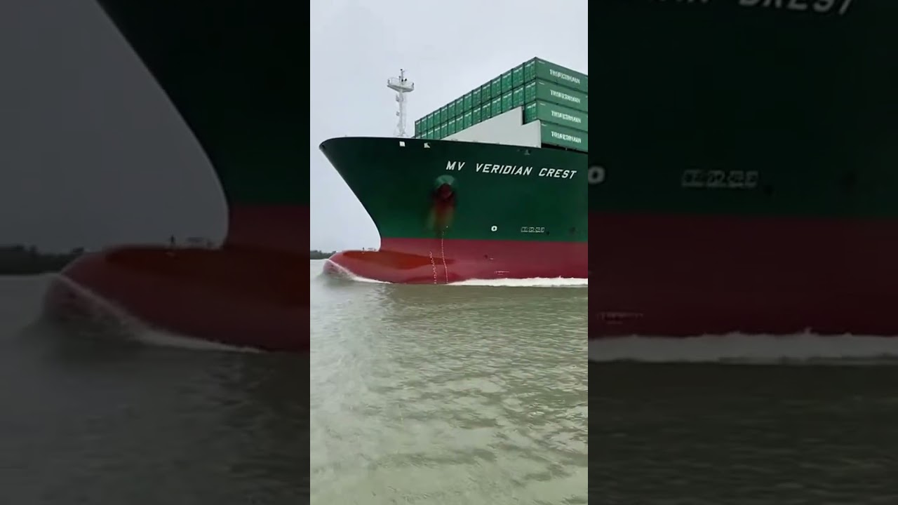 A container ship navigating a major shipping route under overcast skies.