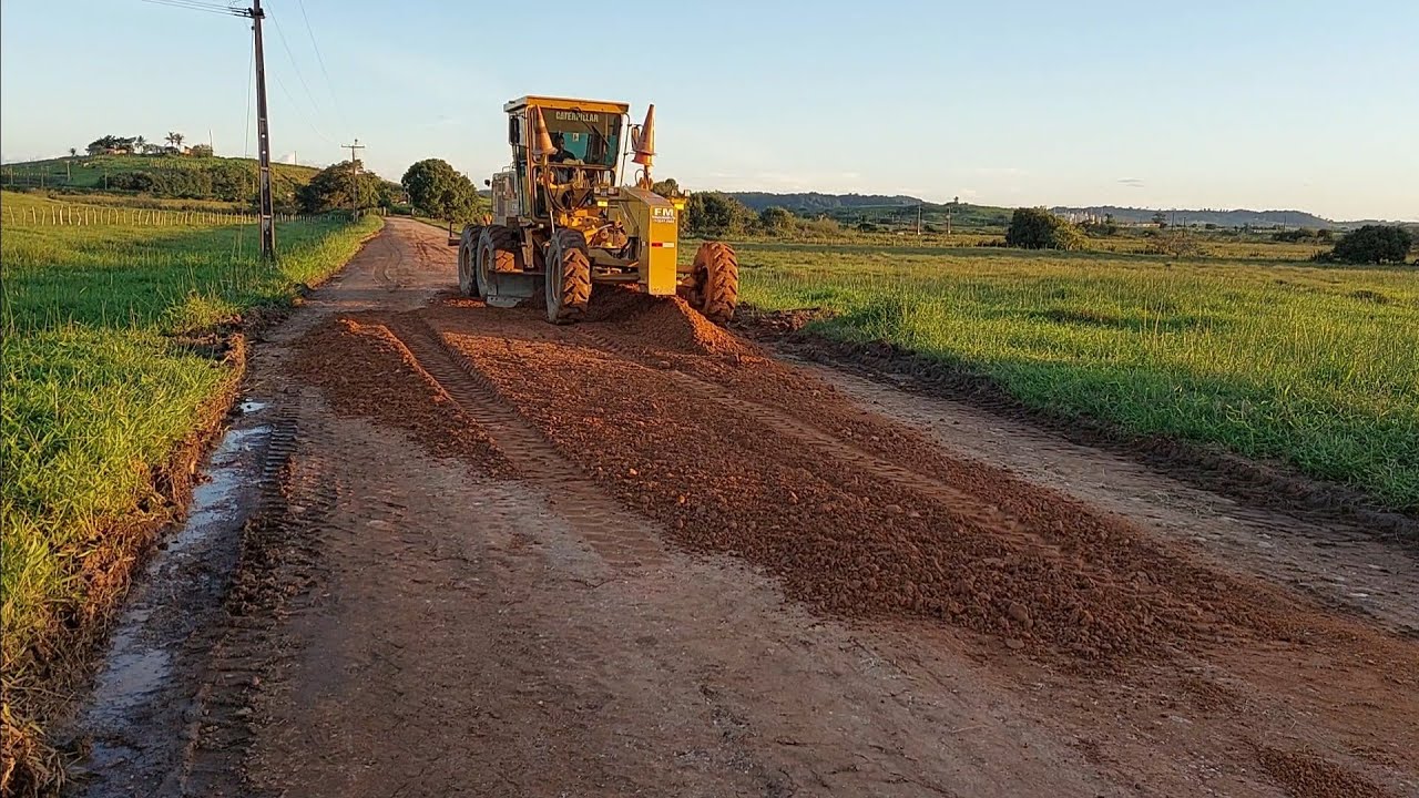 colocando cascalho em buracos estrada rural motoniveladora caterpillar 120k e rolo compactador
