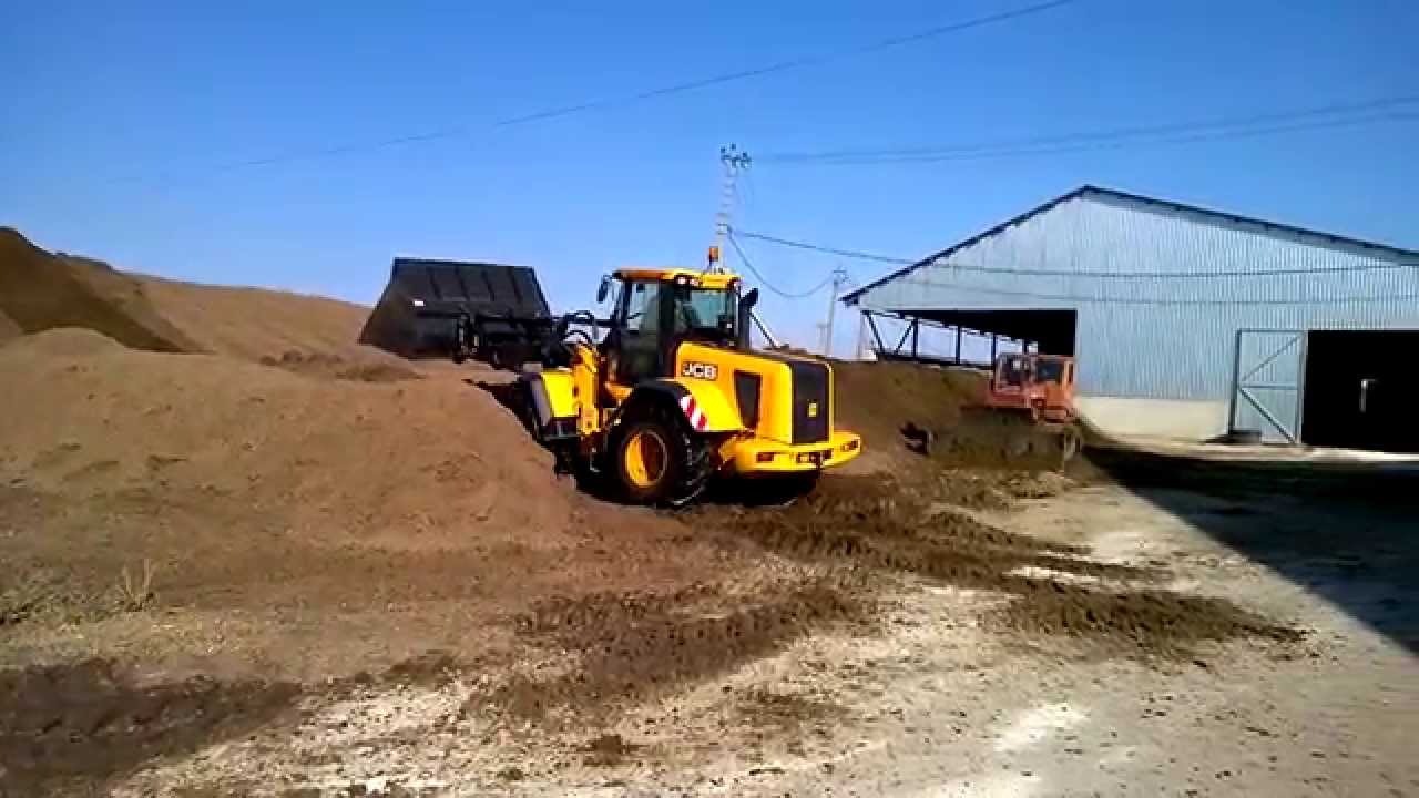 Фронтальный погрузчик JCB Farm Master 434S в работе на сыпучем навозе