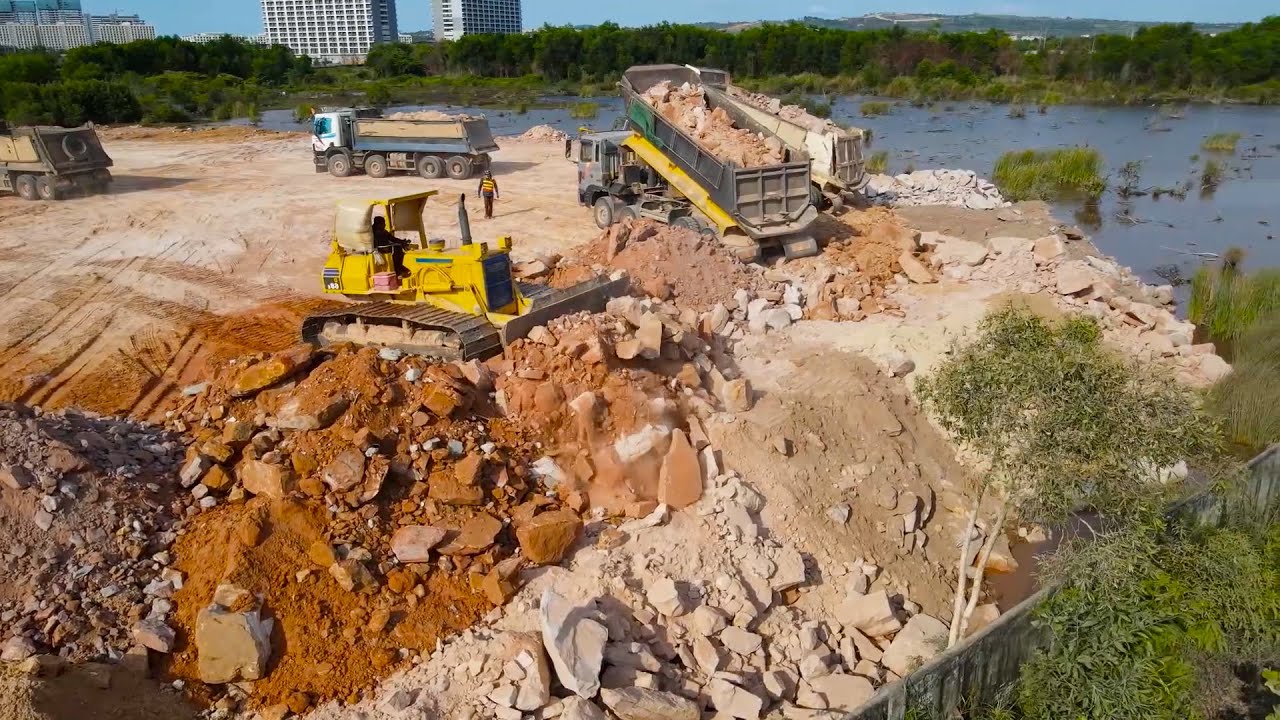 Nice Working Equipment Bulldozer Push Big Stone and Dump Truck Unloading Stone into Water