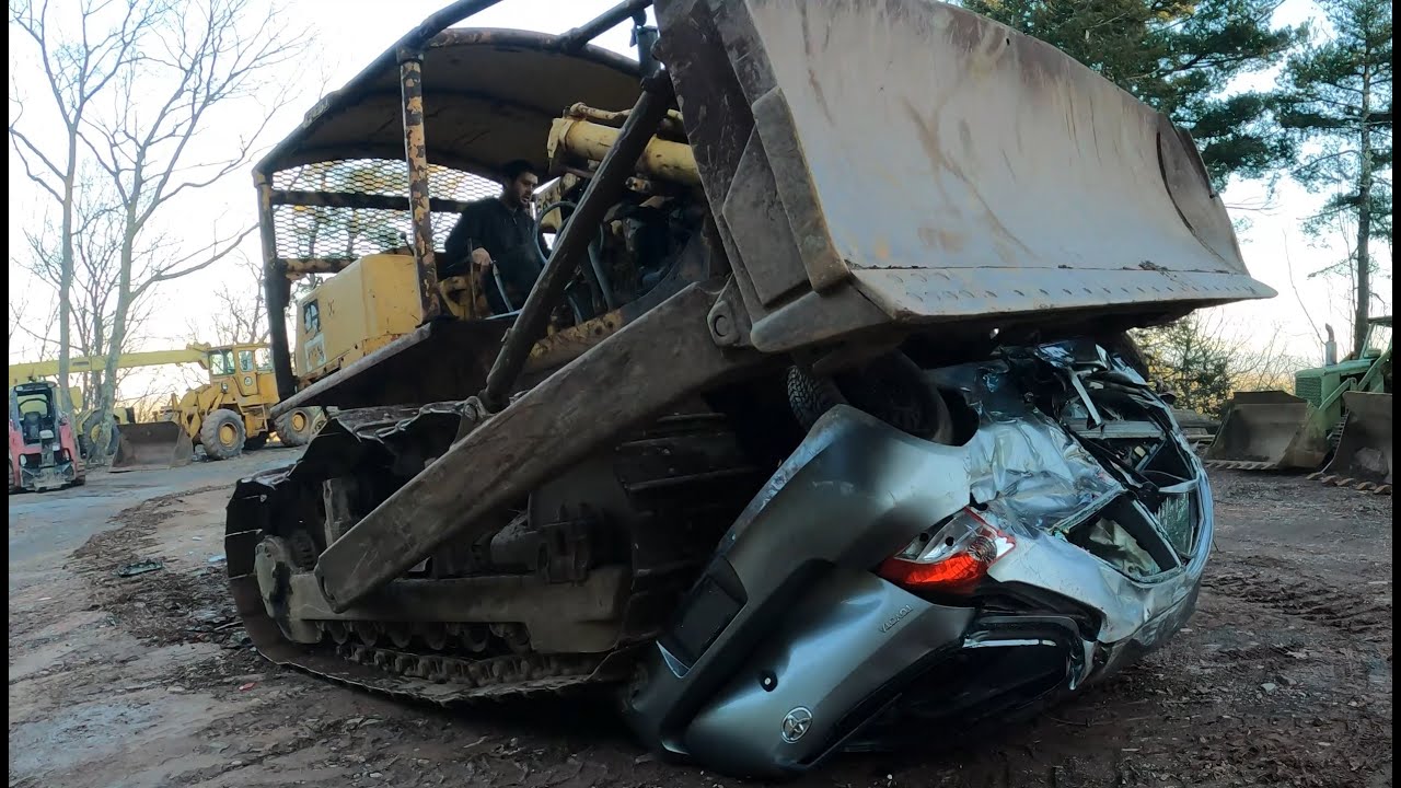 Driving a bulldozer over a car