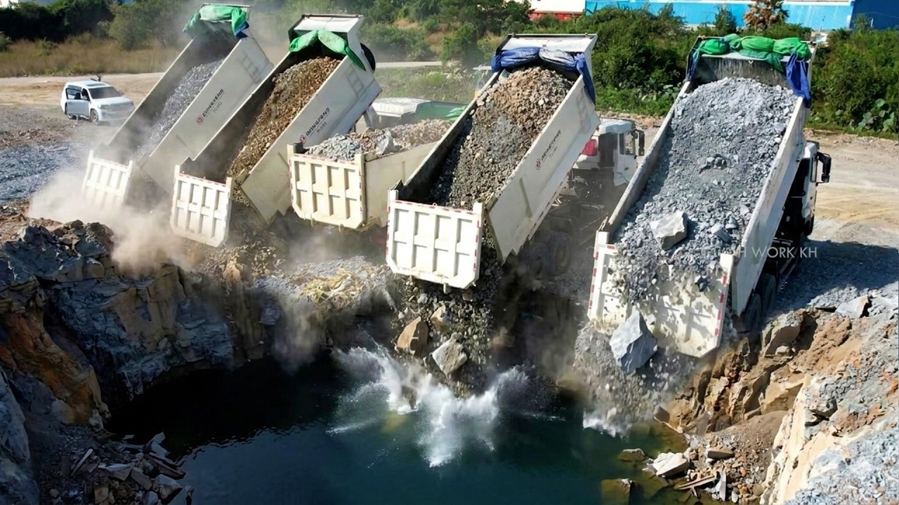 Wonderful Dump Trucks Management Prepairng to Unloading Sttones With Bulldozer Moving in Water