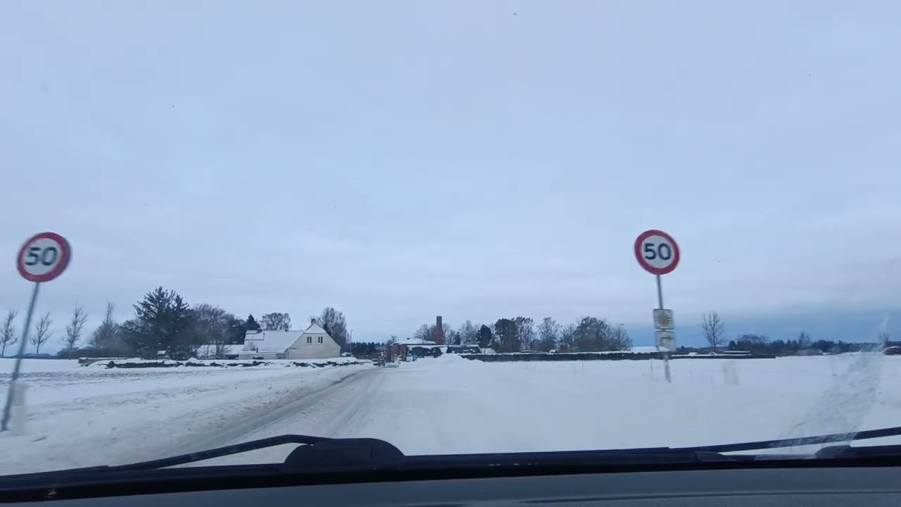 Rural trip through snowy open fields and forests in Northern Denmark 