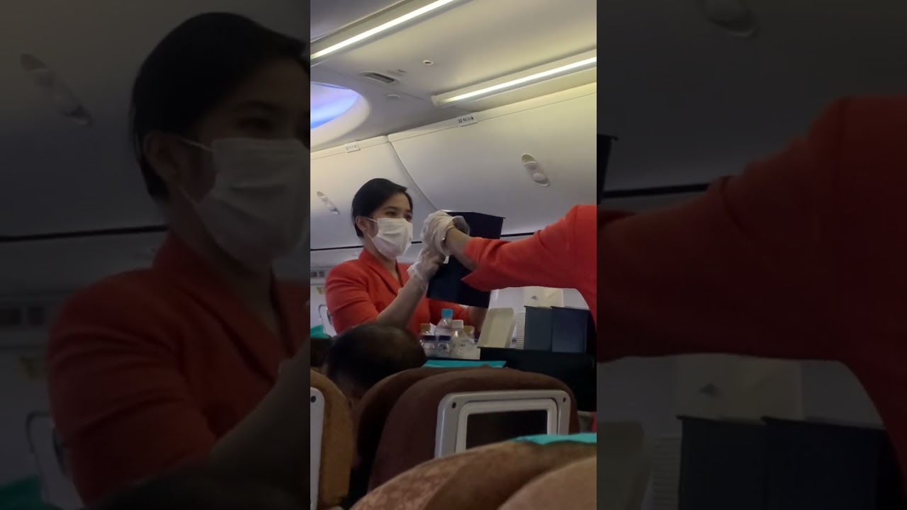 Pramugari cantik Garuda Indonesia sedang melakukan servis makanan di dalam penerbangan Medan Jakarta