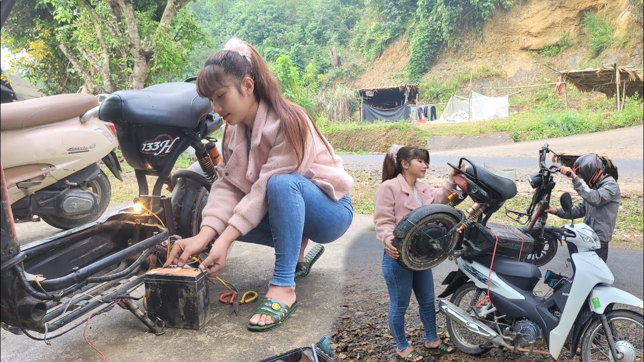 female mechanic repairs an electric vehicle that has lost power due to severely degraded wiring.A