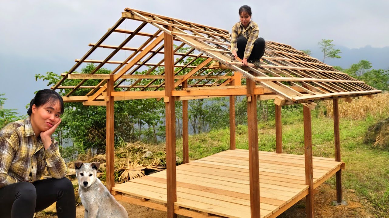 The young girl built a two-story wooden house in the forest. The roofing process.
