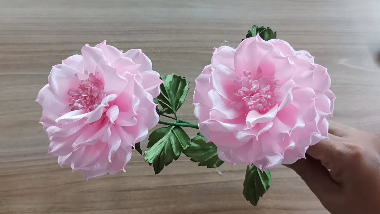 This is an artificial dahlia flower made from pink satin ribbon.