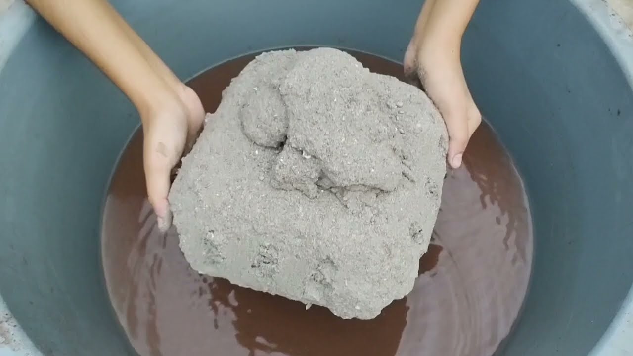 Super soft crunchy grey grainy sand crumbling in water