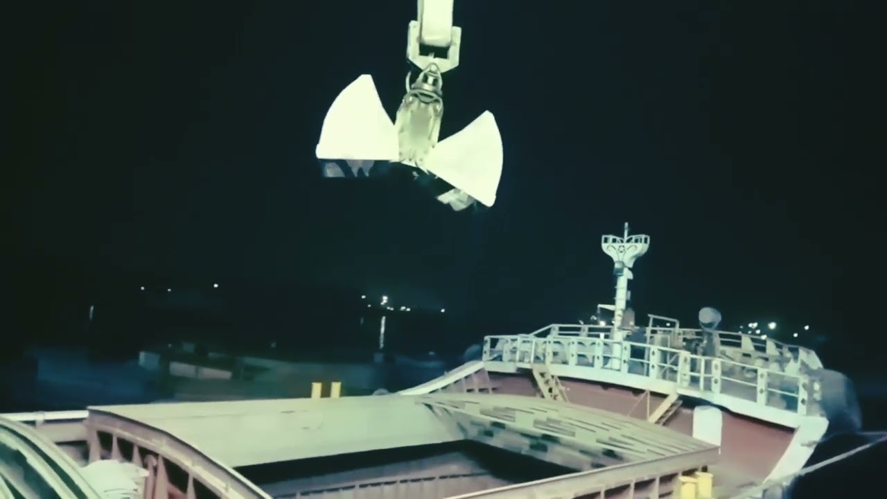 E Crane loading dump truck - heavy equipment transport - stone loading onto ship