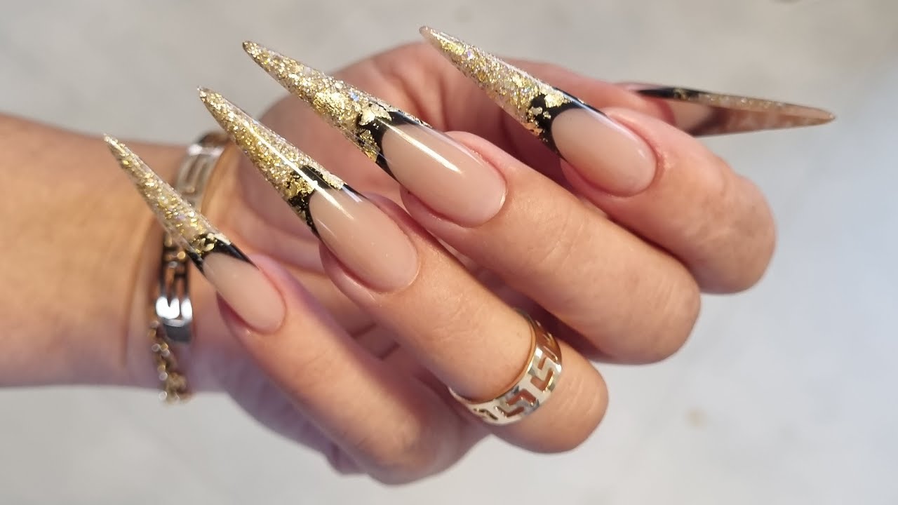 Sculpting stiletto shape nails with buldier gel on forms. Glitter encapsulation with french.