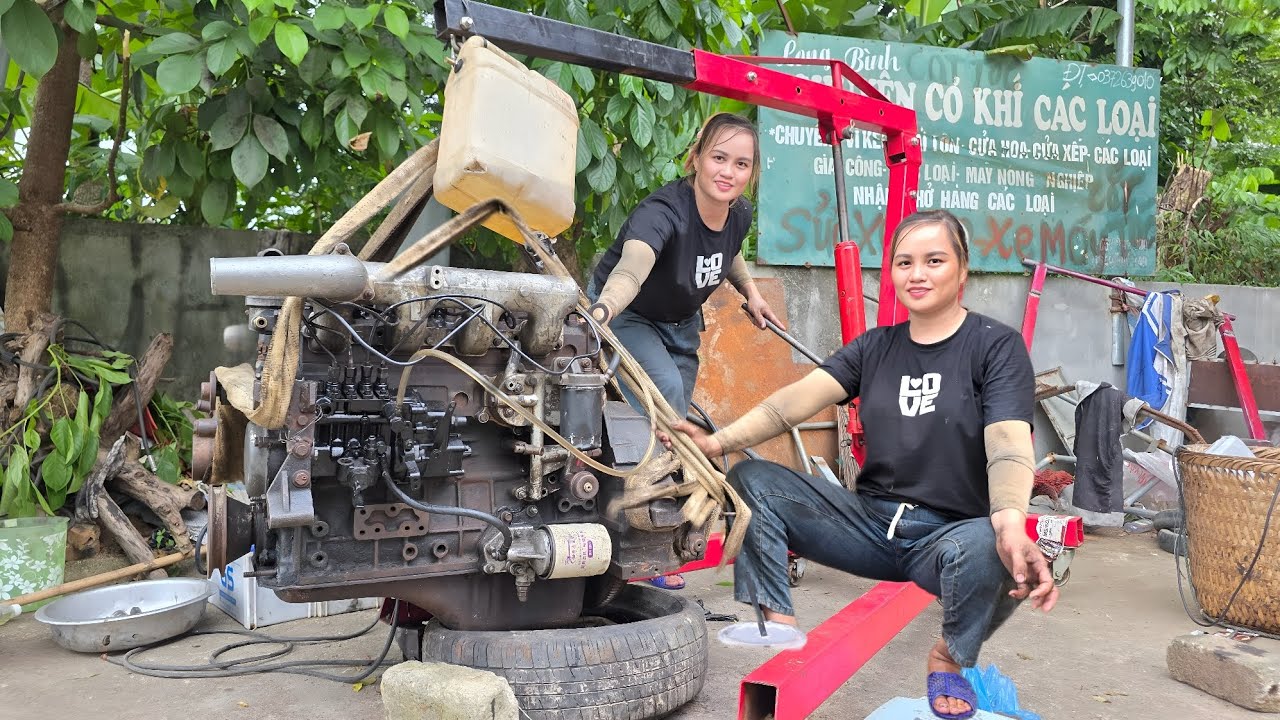 The girl repaired and restored the old engine of the car was flooded.