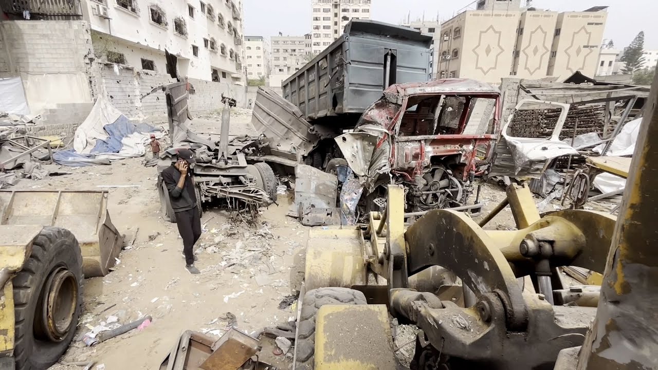 مواطنون يتفقدون معدات ثقيلة قصفتها طائرات الاحتلال الإسرائيلي في مدينة غزة