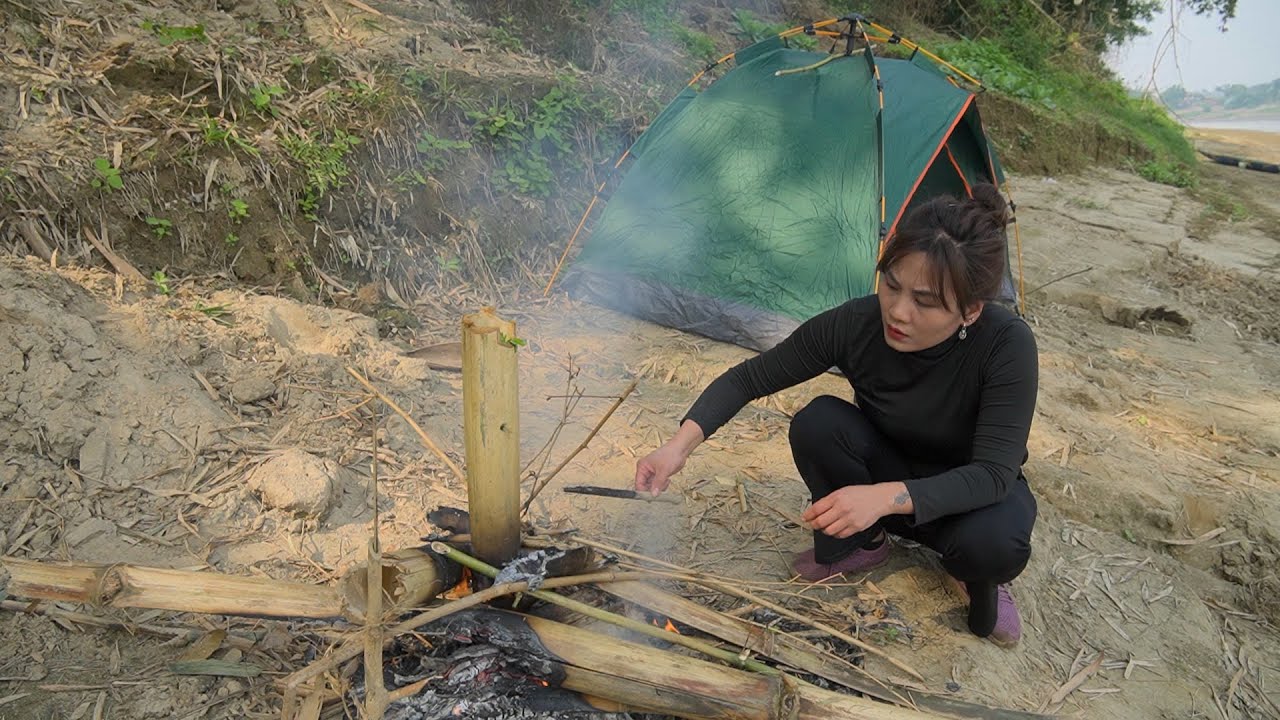 Camping and grilling fish on the riverbank, living off the grid